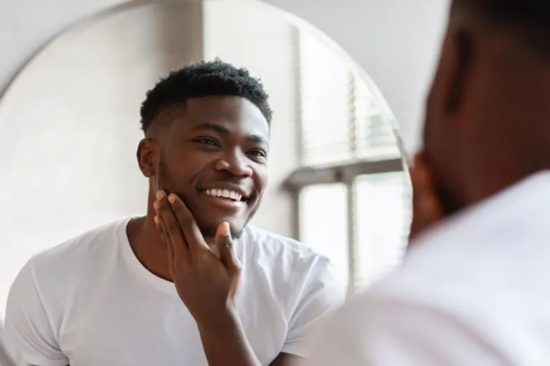 Man looking in mirror at his skin