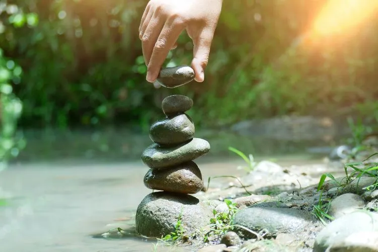 human hand placing rocks